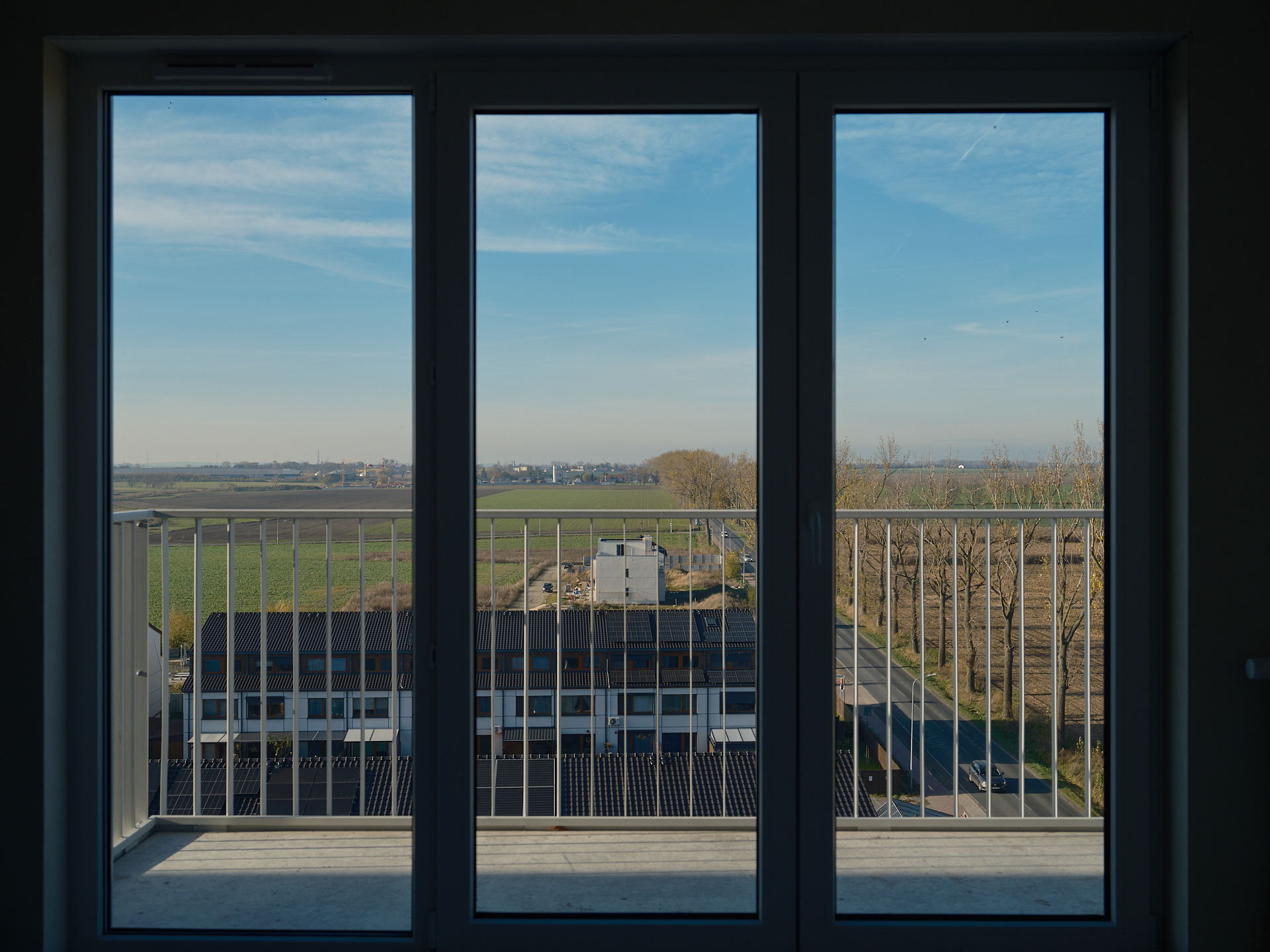 Widok z okna mieszkania na balkon i okolicę